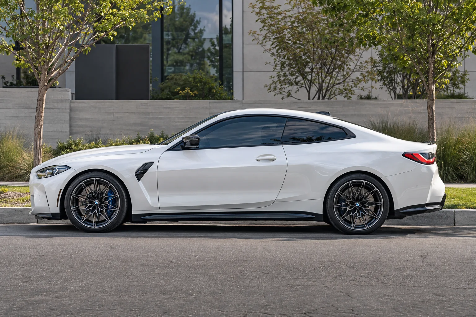 A white BMW M4 with a deep gloss and tinted windows