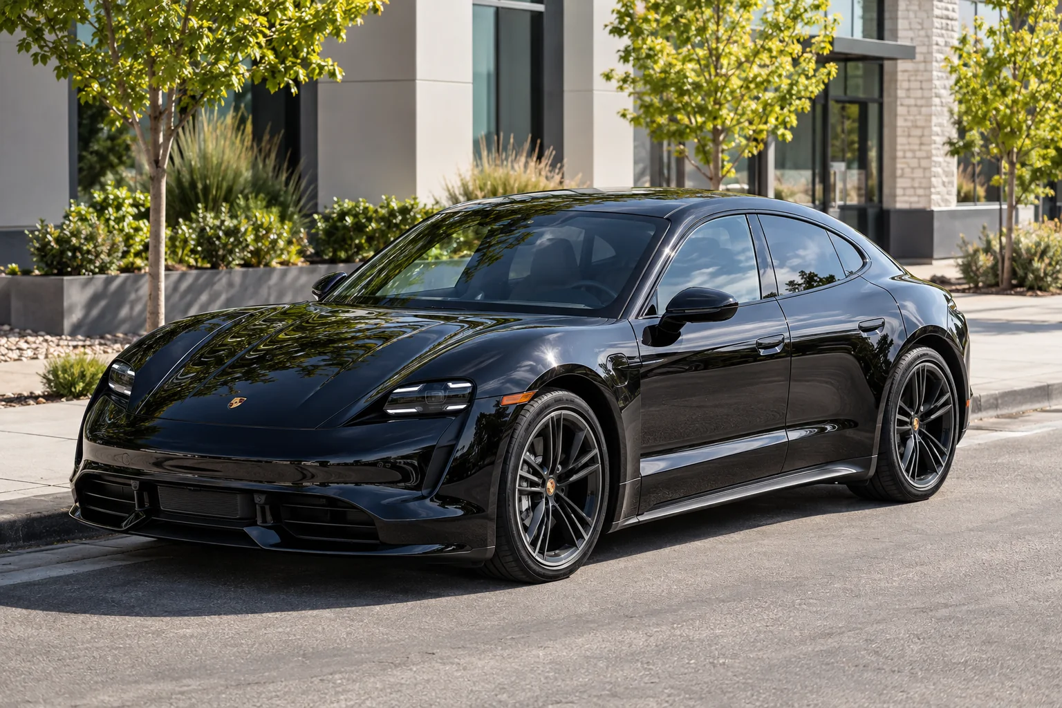 A black Porsche Taycan with ceramic window tint in the sun