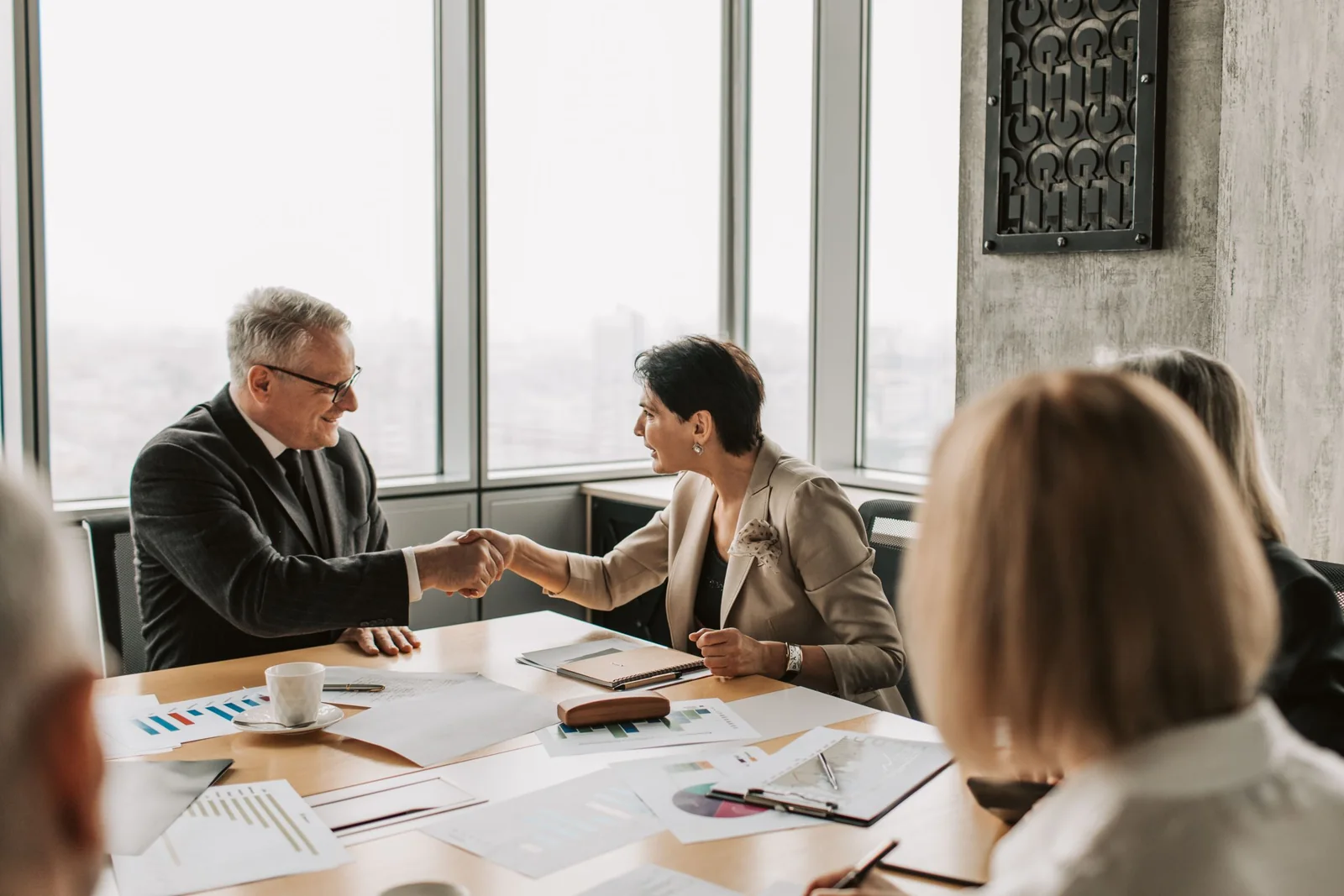 A meeting at a table by tall office windows
