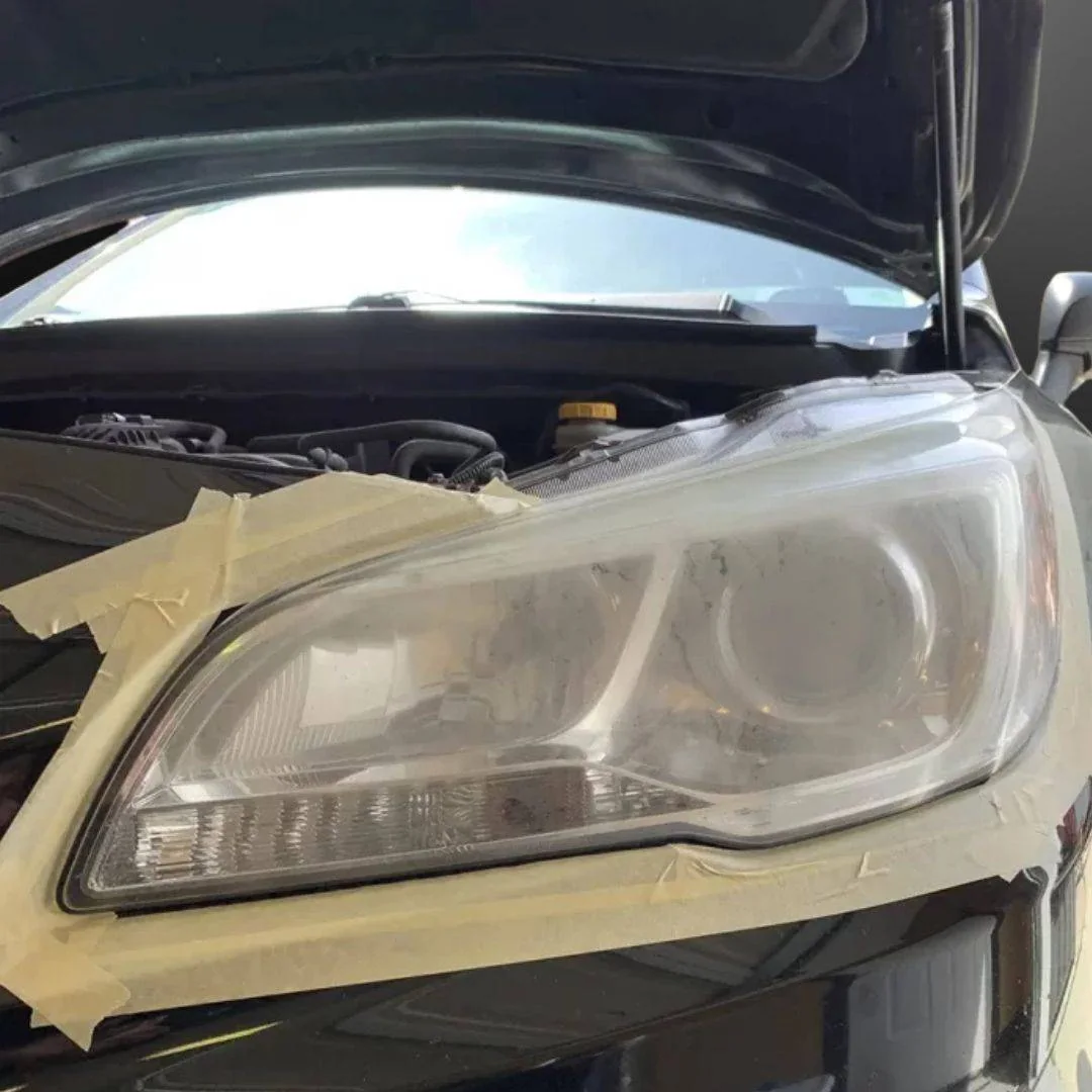 A cloudy headlight taped off, ready to be restored