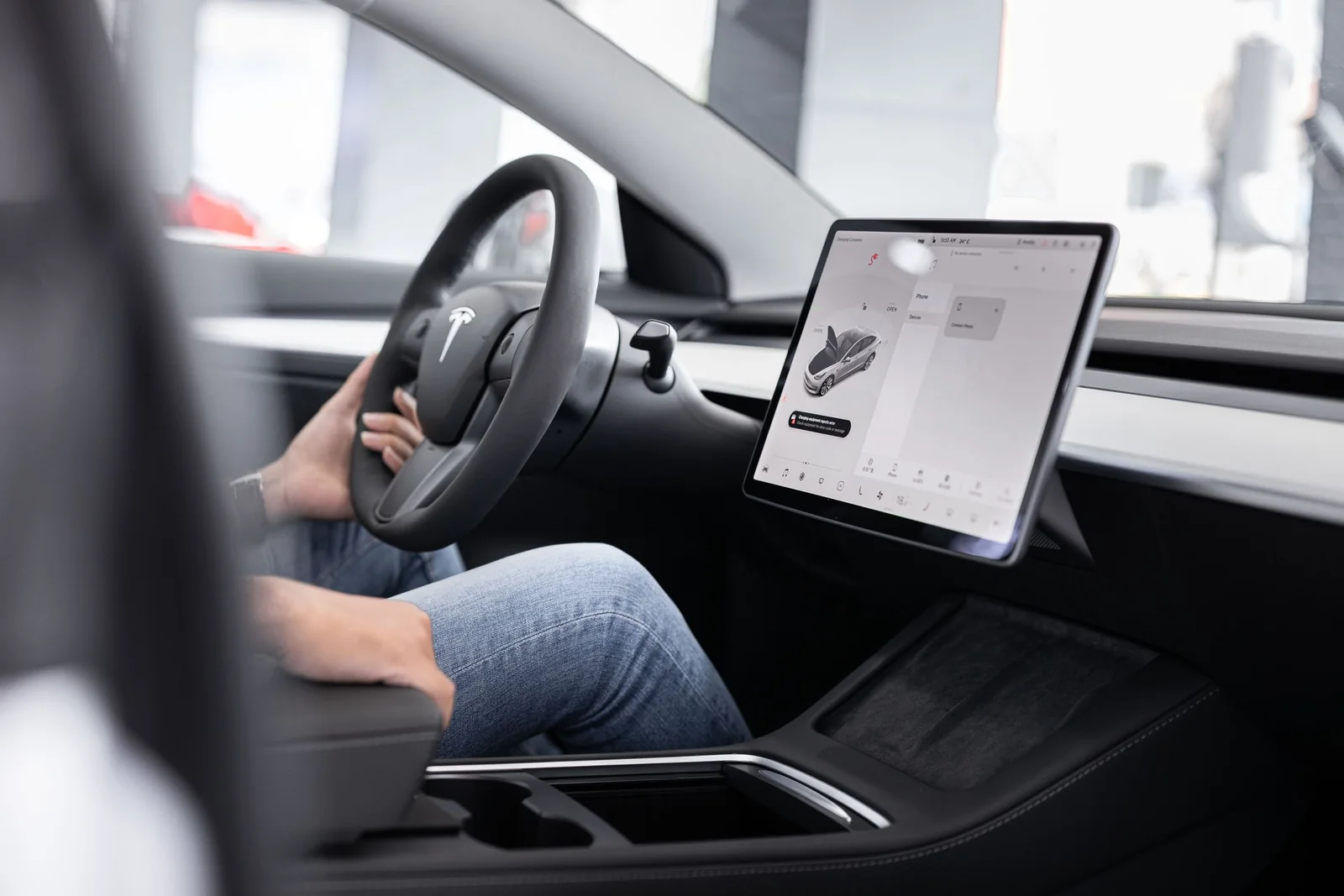 Inside a Tesla, its center screen beside the steering wheel